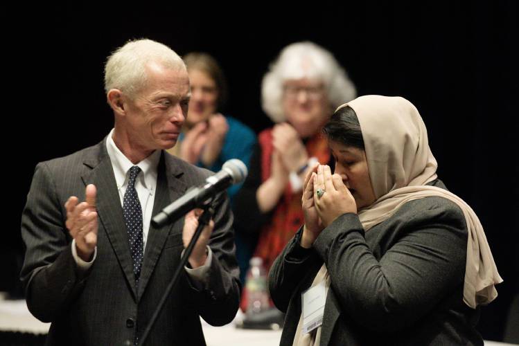 Judge Geeti Roeen, right, collects herself as New Hampshire Supreme Court Justice Gordon MacDonald, left, joins in applauding her at Hanover High School in Hanover on Thursday.