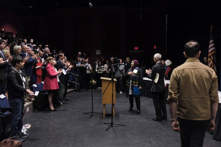 Afghan judge Anisa Rasooli, third from right, receives applause as she approaches the podium at Hanover High School in Hanover on Thursday to speak about her work in Afghanistan and her escape from the country as Taliban forces regained control in 2021.