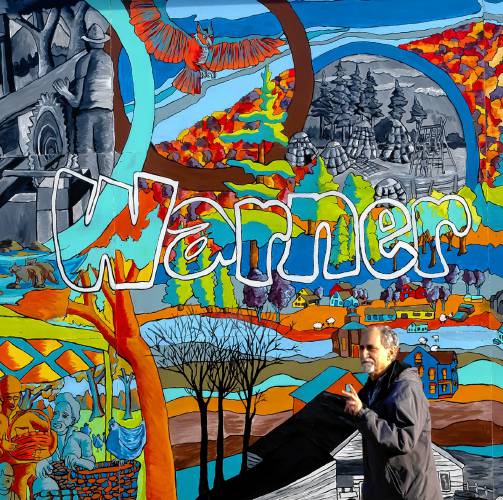 Charlie Albano walks past the mural commissioned on a wall downtown as he gives a tour of Warner earlier this month.