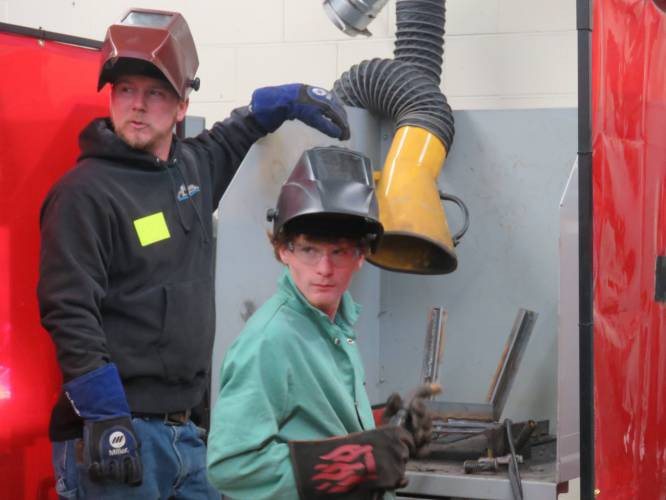 JSRHS student Ethan Guevin (sitting) with MDS employee