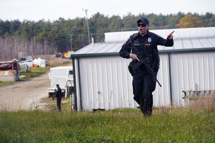 FILE - A police officer gives an order to the public during a manhunt for Robert Card at a farm following two mass shootings, Oct. 27, 2023, in Lisbon, Maine. Despite the warning by Card's friend and fellow Army reservist Sean Hodgson, which came alongside a series of other glaring red flags, Army officials discounted the warnings and ultimately did not stop Card from committing Maine's deadliest mass shooting when he killed multiple people in Lewiston. (AP Photo/Robert F. Bukaty,...