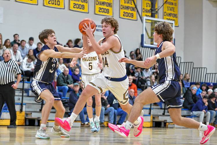 Bow sophomore Jake Reardon splits through two Milford defenders as he drives to the basket during Friday’s game. Reardon led the Falcons with 23 points.