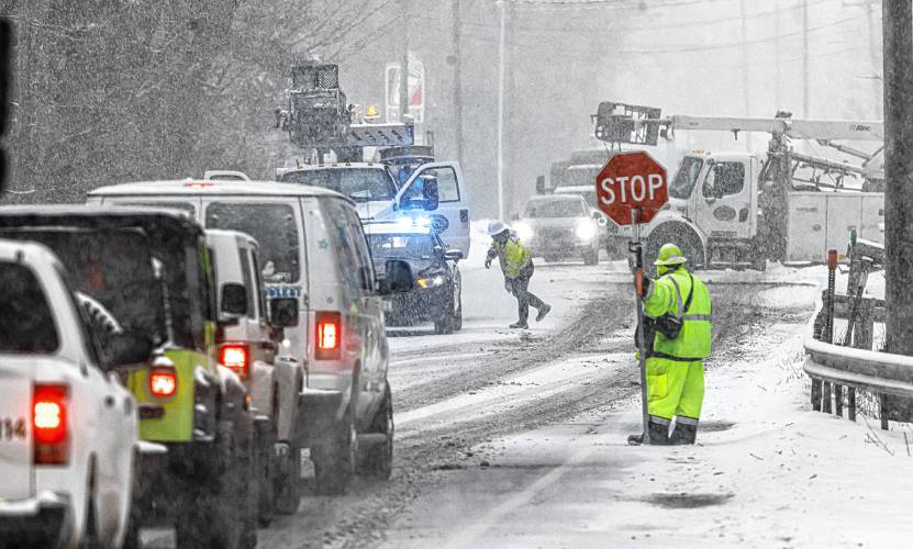 Flagger Dianna St. Laurent directs traffic for a communications company that was working on lines along Route 3 in Tilton during the snowstorm on Tuesday, January 16, 2024. St. Laurent traveled from Pittsfield in the snow for the work.
