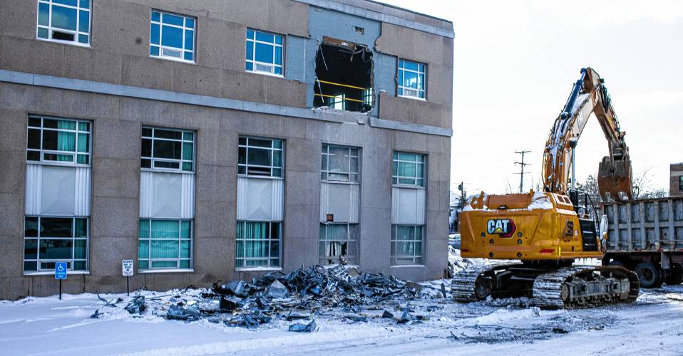 An excavator removes debris from the former Department of Justice building off of Capitol Street in Concord as the demolition of the building started on Wednesday, January 17, 2024.