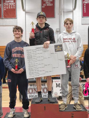 Concord’s Cullen Burke (center) stands at the top of the podium with his trophy after winning the 120-pound title at the Capital City Classic on his home mats on Saturday.