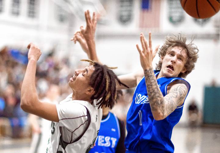 Pembroke forward Javien Sinclair (left) battles with Manchester West forward Max Shosa for a rebound during the first half of Tuesday night’s encounter in Pembroke. The Spartans shook off a late West rally to prevail in overtime, 66-62.