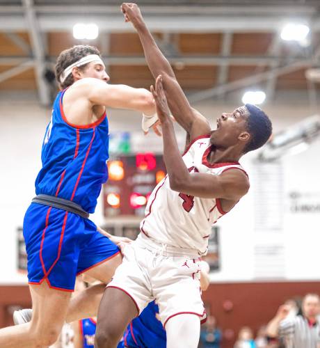 Concord forward Alain Twite gets fouled by Winnacunnet forward Andrew Simmons at the buzzer ending the first quarter on Friday night. Twite went to the foul line for three shots after the foul.