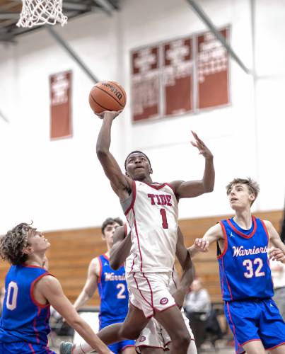 Concord guard Japhet Nduwayo scores on a one-handed layup against three Winnacunnet players during the second half on Friday night.