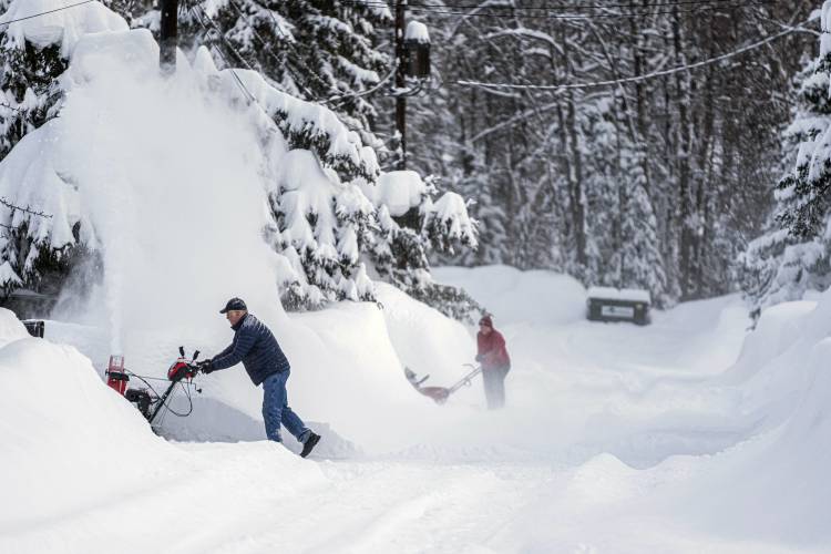 People blow snow from their driveways, Monday, Jan. 29, 2024, in West Anchorage, Alaska. (Loren Holmes/Anchorage Daily News via AP)
