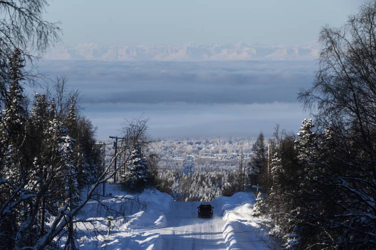 A vehicle travels west on Upper Huffman Road on a frosty and foggy afternoon in Anchorage, Alaska, Feb. 1, 2024. (Marc Lester/Anchorage Daily News via AP)