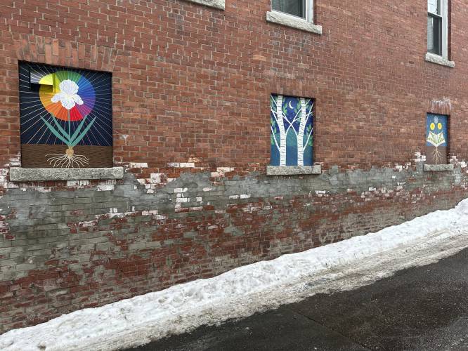 Murals deemed objectionable by some residents hang on the side of building in Littleton, N.H., on Jan 23, 2024. Littleton town manager Jim Gleason, whose late son was gay, resigned effective Friday, Feb. 2, 2024, to take a stand against the anti-LGBTQ sentiments being expressed by some people in Littleton. The quaint town of Littleton is seeing more tourists, drawn to a main street of shops and restaurants where rainbow colors and gay pride symbols can be seen alongside American...