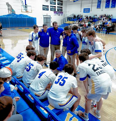 Kearsarge boys’ basketball coach Nate Camp (center) talks with his starters before a game this season at Kearsarge Regional High School in North Sutton.