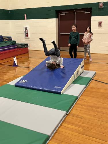 (From back) Hatley Nye, Mya Mello and Kendal St. Onge play on the gym mat.