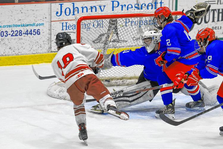 Concord junior Rowan Arndt fires the puck past Trinity goalie Brendan Heppler during Wednesday's 4-2 win for the Tide.