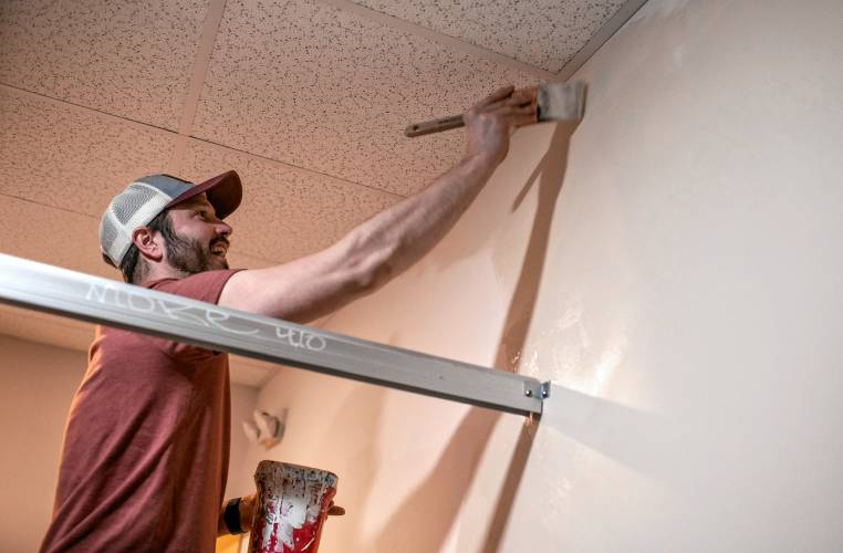 Zak Jentzen paints the walls in the bathroom of Dos Amigo’s in downtown Concord on Tuesday. Jentzen usually works in the kitchen but is helping with the renovation.