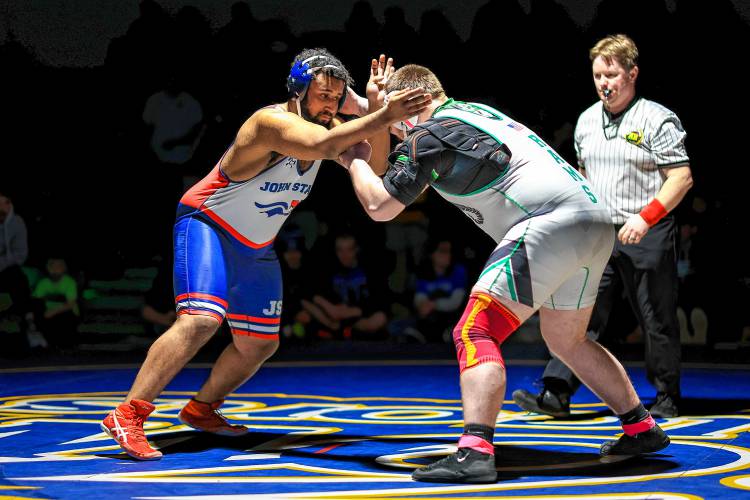 John Stark’s Isaac Coker (left) grapples with Raymond’s Hayden Robinson in the heavyweight final at the Division III wrestling championship on Saturday at Bow High School. Coker was the 285-pound runner-up.