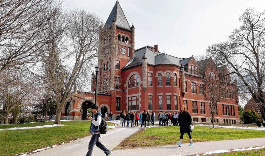 In this photo taken Wednesday April 6, 2016 students walk past the historic Thompson Hall at the University of New Hampshire in Durham, N.H. The water system serving the University is among more than two dozen in New Hampshire that have exceeded the federal lead standard at least once in the last three years. (AP Photo/Jim Cole)