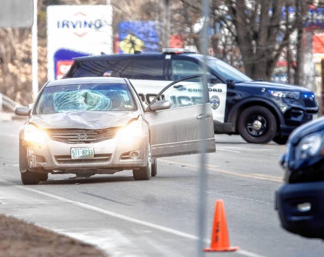 A car with a broken windshield sits in the southbound lane of Fisherville Road in Concord as police investigate an accident on Wednesday.