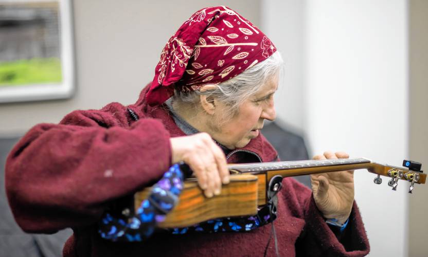 Laurel Flax tunes up the ukulele before the group gathers for practice at the Hopkinton community room at the library on Tuesday, February 20.