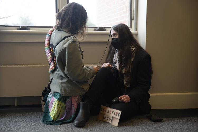 Dartmouth junior Marion Caldwell, left, braids junior Roan Wade’s hair as Wade awaits her trial for misdemeanor criminal trespassing at Lebanon District Court in Lebanon on Monday.