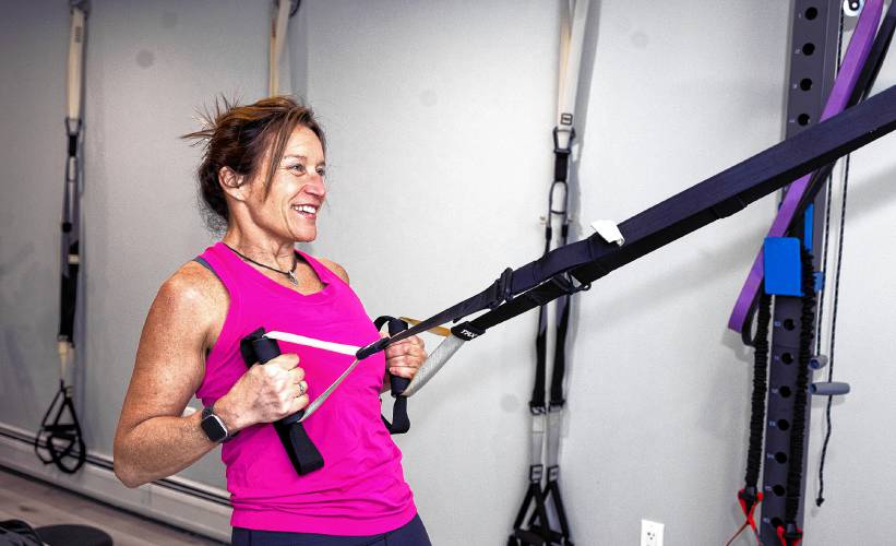 Liz Littell of Center Harbor works out in her fitness center in Meredith on Feb. 28.