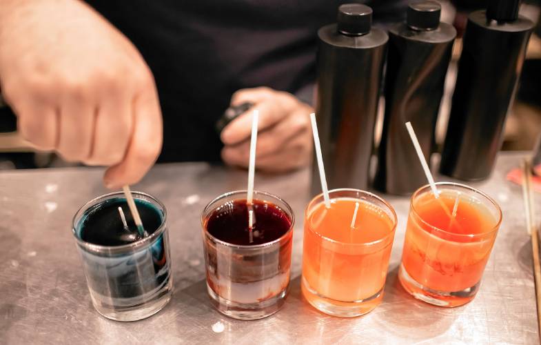 Ross Mingarelli hand stirs the hot soy wax to create the marbling effect for his speciality candles at is downtown Candle Tree Soy Candle shop.