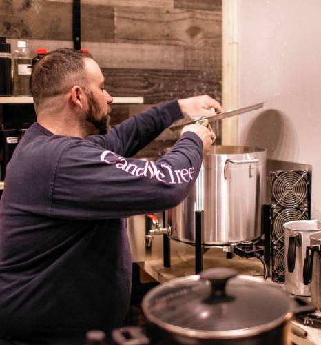 Ross Mingarelli stirs the hot wax for his candles at is downtown Candle Tree Soy Candle shop. Mingarelli has over 600 different scents for his candles.