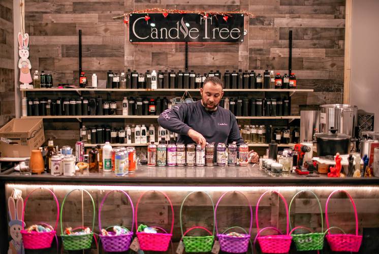 Ross Mingarelli pours the hot soy wax for his specialty beer can candles at his downtown Candle Tree Soy Candle shop in Concord.