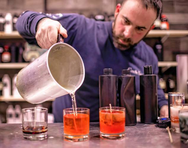 Ross Mingarelli pours the hot soy wax for his speciality candles at is downtown Candle Tree Soy Candle shop.