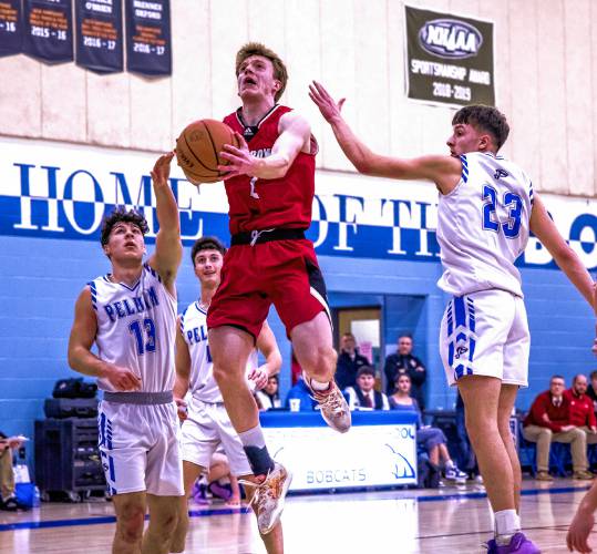 Coe-Brown forward Connor Bagnell slices down the lane between two Pelham defenders during the first of half at Oyster River High School on Tuesday night, March 5, 2024 during the Division II semifinal game.
