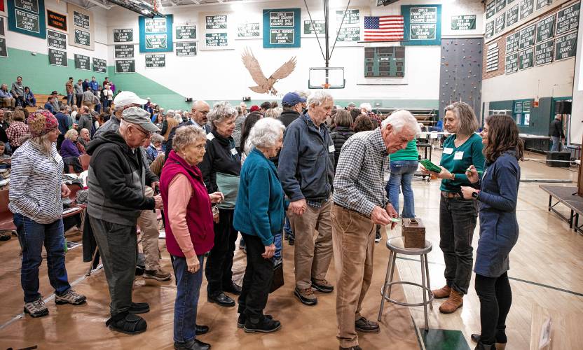 Hopkinton resident John Madden looks down at his ballot during the secret SB2 voting at Hopkinton High School on Saturday, March 9, 2024.