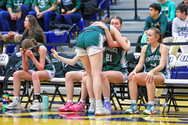 Pembroke’s Kaitlin Arenella hugs senior Annelise Dexter (21) after the Spartans lost to Concord Christian in the Division II championship game at UNH on Sunday.