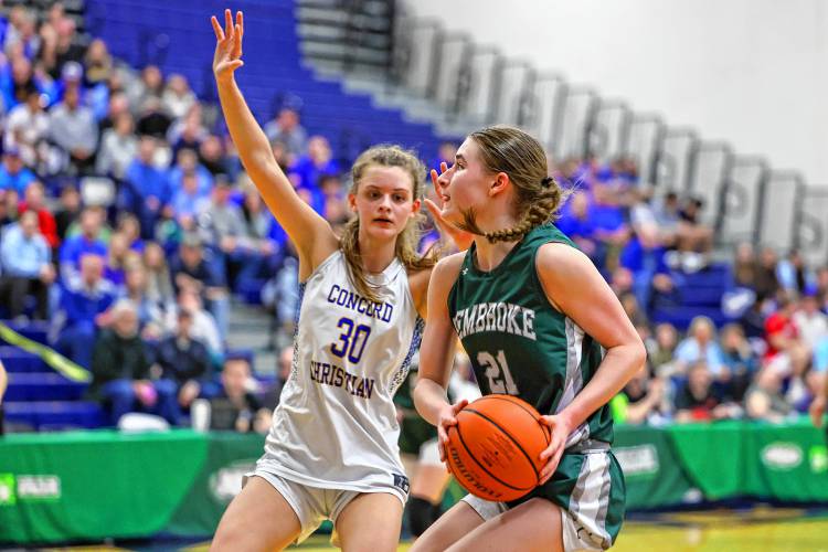 Annelise Dexter drives to the basket with CCA’s Emma Smith defending her during the D-II championship game at UNH on Sunday.