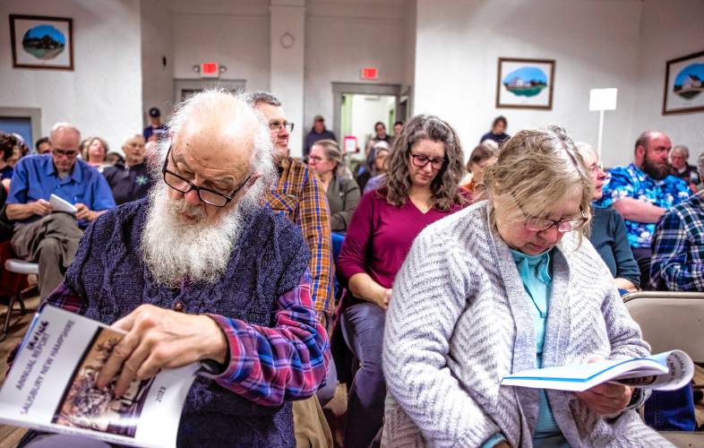 Salisbury residents Bob Irving and his cousin Helen Zampino look over the annual town report Tuesday at the town hall.