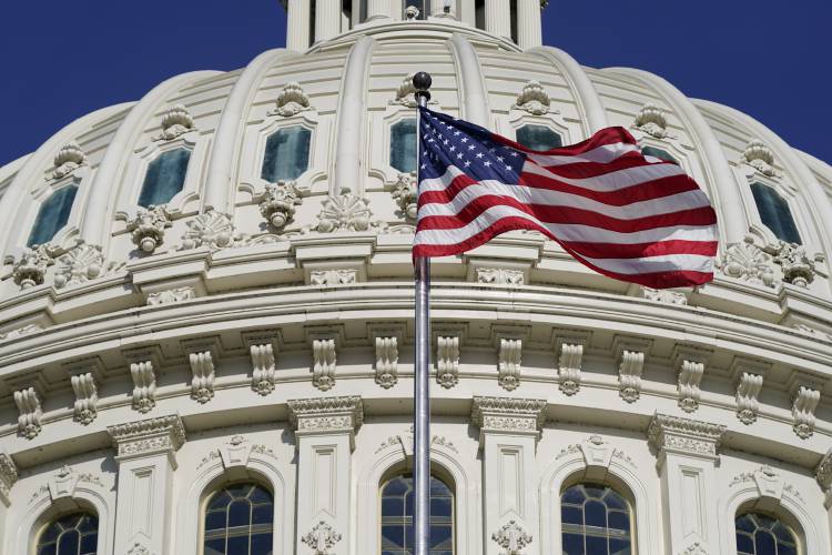 FILE - An American flag waves below the U.S. Capitol dome on Capitol Hill in Washington, June 9, 2022.