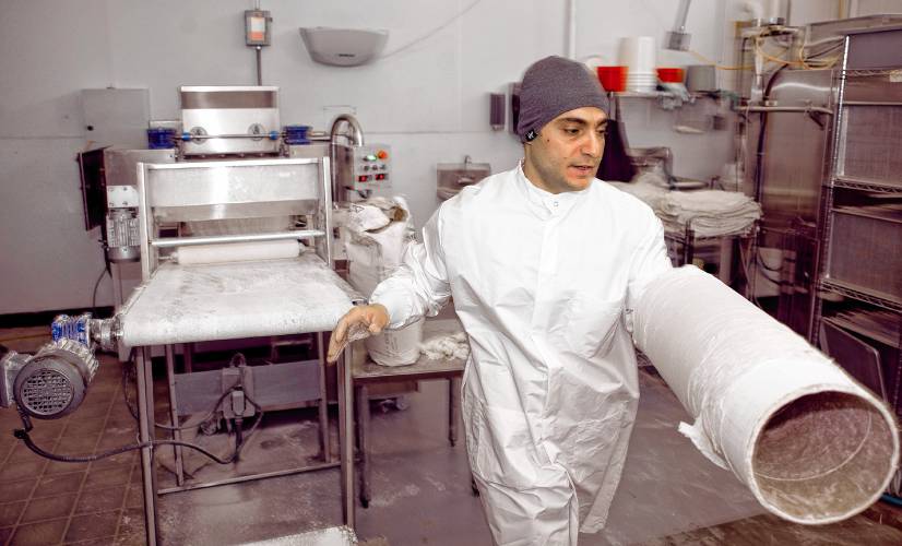 Aissa Sweets owner, Amhad Aissa, moves the the roll paper-thin dough to make the custom Baklava at his production facility on Hall Street in Concord on March 8, 2024.